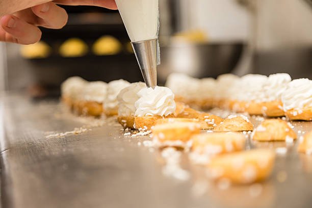 chef prepating cake with a pastry bag